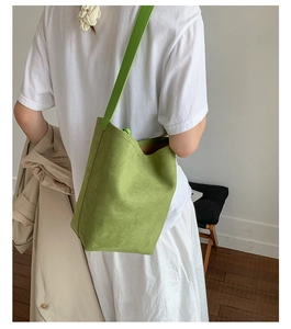 Detail of matte matcha green bucket bag showing suede texture and smooth shoulder strap