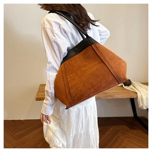 Vista de detalle del bolso tote de ante marrón grande con asas de cuero negro