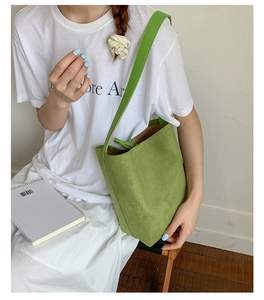 Detail of green suede tote bag showing minimalist design and smooth matte texture
