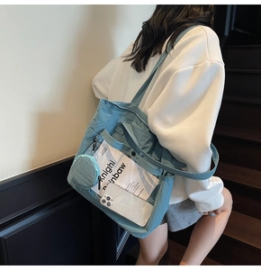 Blue nylon tote bag detail featuring a transparent PVC front pocket and mini coin purse