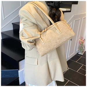 Detail view of a beige suede Boston bag with double zippers and elegant textures