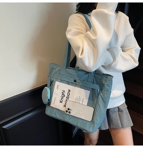 Blue canvas tote bag with transparent front pocket and matching small round coin purse