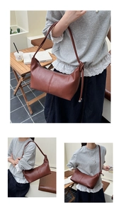 Detailed view of brown leather croissant bag with knotted strap and silver metal beads