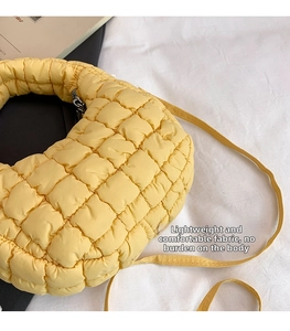 Close-up of bright yellow quilted dumpling bag with adjustable shoulder strap