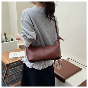 Macro view of vintage dark brown faux leather bag with knotted shoulder strap detail