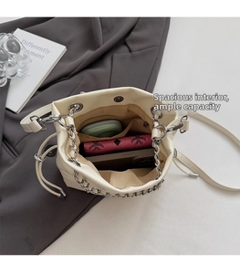 Top view of cream bucket bag showing spacious interior with silver chain and drawstring