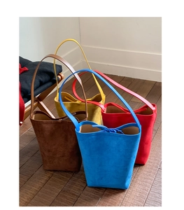 Detail of candy-colored frosted suede bucket bags in brown, yellow, red and blue