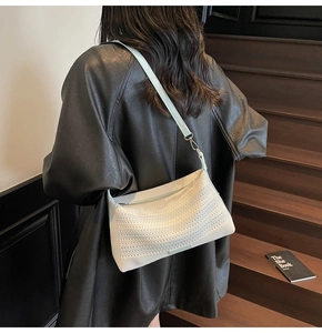 Dettaglio della borsa hobo bianca intrecciata con trama traforata e tracolla sottile