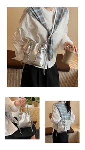 Detail of silver metallic bucket bag with chain strap and drawstring closure shown on model