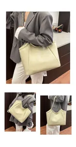 Détail de la texture grainée et de la bandoulière chaîne de ce sac fourre-tout crème