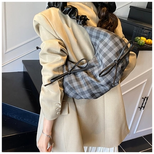 Detail der karierten Hobo-Tasche mit schwarzen Schleifen und Faltengurt am Model