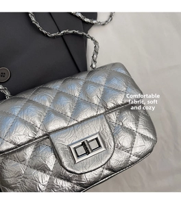Détail du sac argenté matelassé avec texture froissée et fermoir pivotant en métal