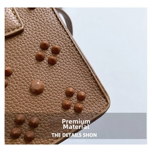 Détail du cuir grainé marron avec rivets décoratifs et finitions texturées haut de gamme