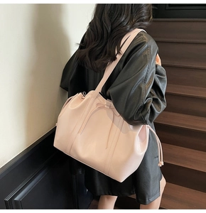 Detail view of pink large tote bag with bow accent and side drawstring on model