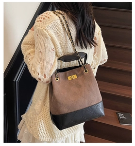 Detail of vintage quilted tote bag with brown textured fabric and gold turn-lock closure