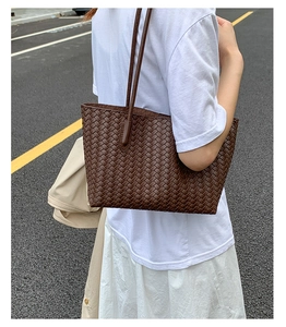 Deep brown large woven tote bag shown on model for over-the-shoulder styling