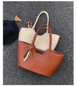 Close-up of woven tote bags in brown and beige with stylish wooden bead charms