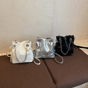 Minimalist drawstring bucket bag in off-white, silver, and black faux leather finish