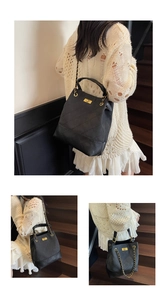 Detailed view of the large black quilted leather tote with gold chain strap and metal lock