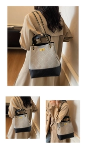 Detail of grey quilted bucket bag featuring a gold twist lock and metal chain strap