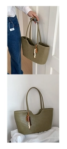 Macro detail of olive green woven tote bag with vintage wooden bead tassel ornament