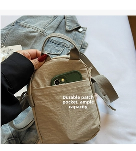 Close-up of khaki nylon crossbody phone bag showing front pocket storage and capacity