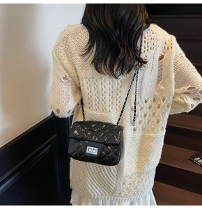 Gros plan sur le sac bandoulière matelassé en cuir verni noir avec chaîne argentée