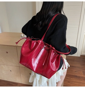 Detail der roten Lackleder-Beuteltasche mit Tunnelzug und eleganter Schleifenverzierung