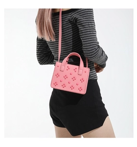 Détail du sac à main en cuir rose avec décoration florale 3D unique et bandoulière