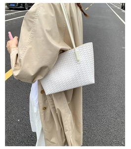 Close-up of white woven leather texture on a vintage tote bag shown in street photography