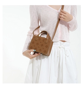 Vue détaillée du sac bandoulière en cuir marron avec fleurs 3D et poignée ronde rigide