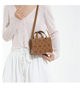Détail du petit sac carré marron avec rivets floraux et bandoulière réglable pratique