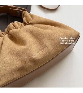 Gros plan sur la texture en daim plissé beige et le relief de ce grand sac à main
