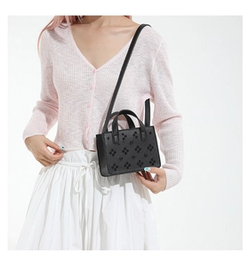 Détails du mini sac cabas en cuir grainé noir avec clous fleuris et anses anneaux