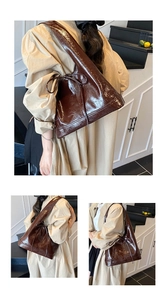 Close-up of glossy brown bucket bag featuring a decorative bow and textured leather