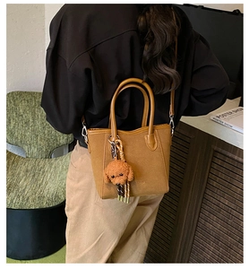 Vintage Braune Beuteltasche in Wildlederoptik mit Hundekette an einem Model in gemütlicher Szene