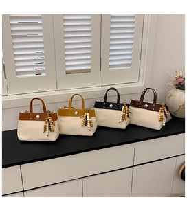 Detalle de bolsos tote de lona en cuatro colores con ribete de cuero y borlas de cuentas