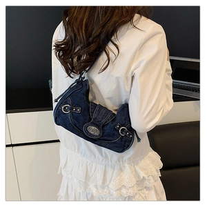 Close-up of retro denim crescent bag featuring contrast stitching and metal twist lock