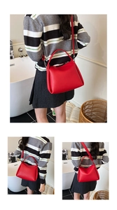 Détails du sac seau en cuir rouge avec boucles argentées et bandoulière réglable