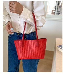 Close-up of red woven leather tote bag featuring classic intricate interlaced craftsmanship