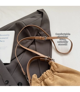 Détails de la bandoulière en cuir réglable et boucle argentée sur sac en daim kaki