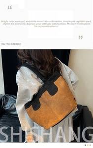 Detailed side view of a large brown and black suede tote bag with a wide shoulder strap