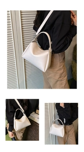Détails d'un sac seau blanc en cuir grainé avec finitions argentées et bandoulière amovible