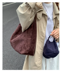Detail of dark brown suede tote bag with soft texture paired with a beige trench coat