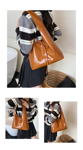 Macro view of caramel brown glossy leather tote bag with stylish drawstring bow detail