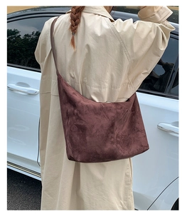 Detail view of dark brown suede tote bag worn over the shoulder for daily commuting