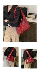 Detail of a shiny red patent leather tote bag with vintage bow drawstring and large capacity