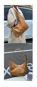 Detail of adjustable wide shoulder strap on a brown suede tote bag for daily commute