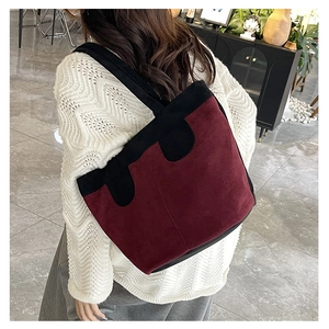 Détail du grand sac cabas en daim bordeaux avec coutures ondulées noires élégantes