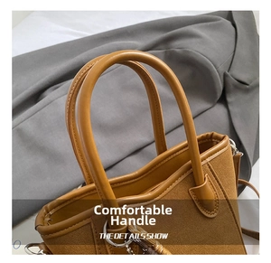 Nahaufnahme des karamellfarbenen Griffs und der Wildleder-Textur einer Bucket Bag
